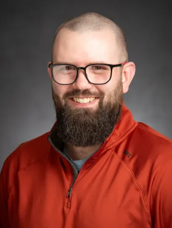 travis klath headshot in dark orange shirt