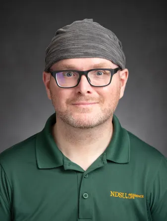 josh onken headshot in green residence life polo