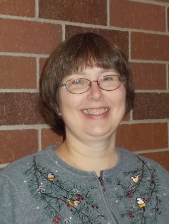Laurie Geyer standing against a wall
