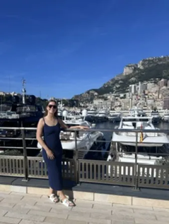 a student standing on a bridge in front of a port with many boats