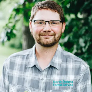 A man with glasses smiles