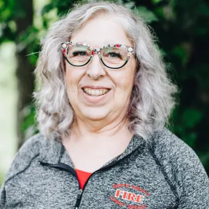 A woman with glasses smiles