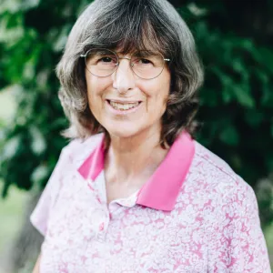 A woman with glasses smiles