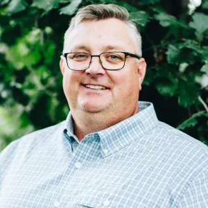 A man with glasses smiling