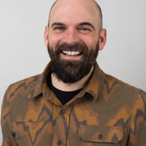 Josh Zeis looking confidently at the camera with a big smile.