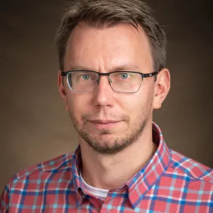 Alexey Leontyev smiling confidently at the camera