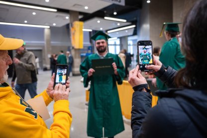 A student's family takes a picture during commencement