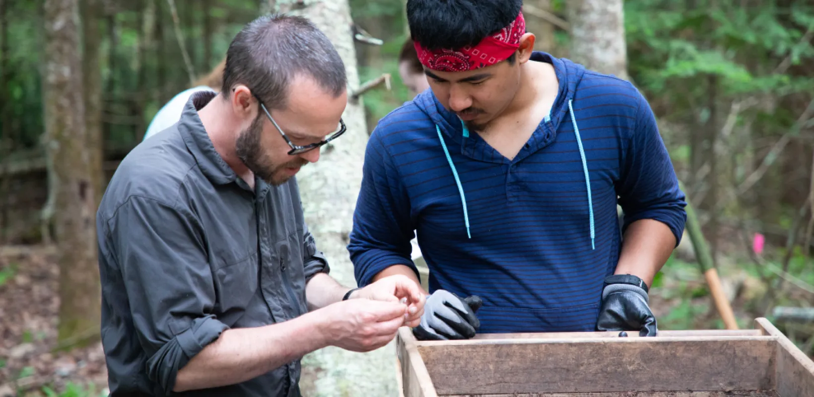 student and professor working at an anthropology dig site