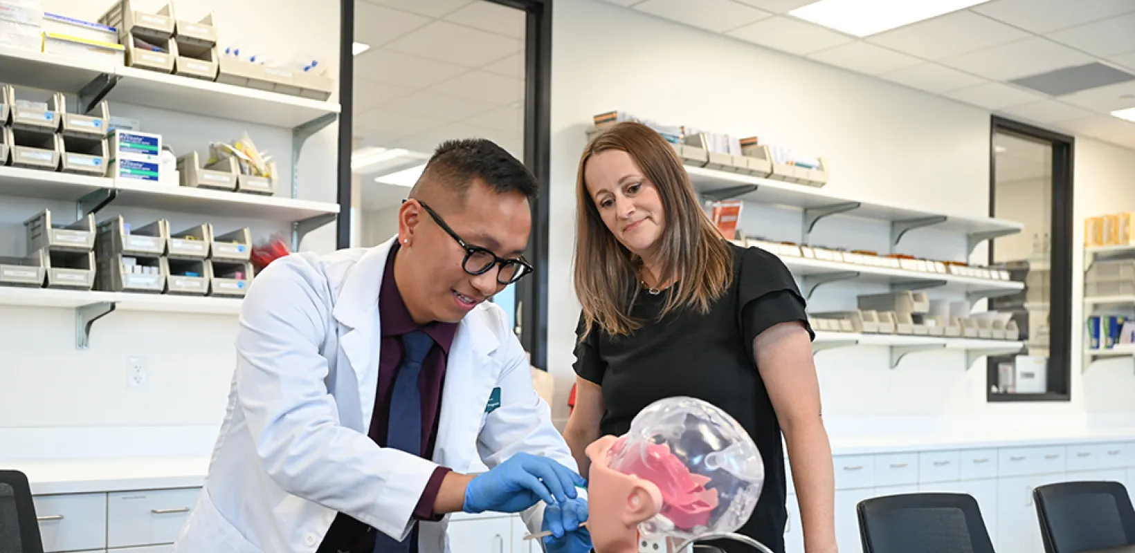 student practices administering medicine while faculty member observes