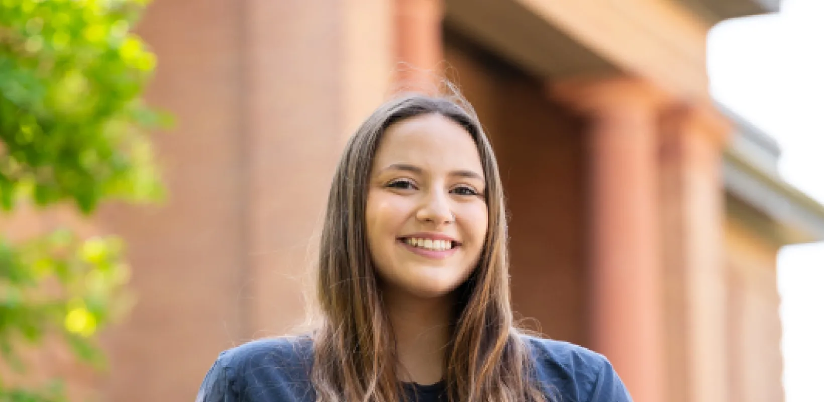 Student sitting in front of admission building