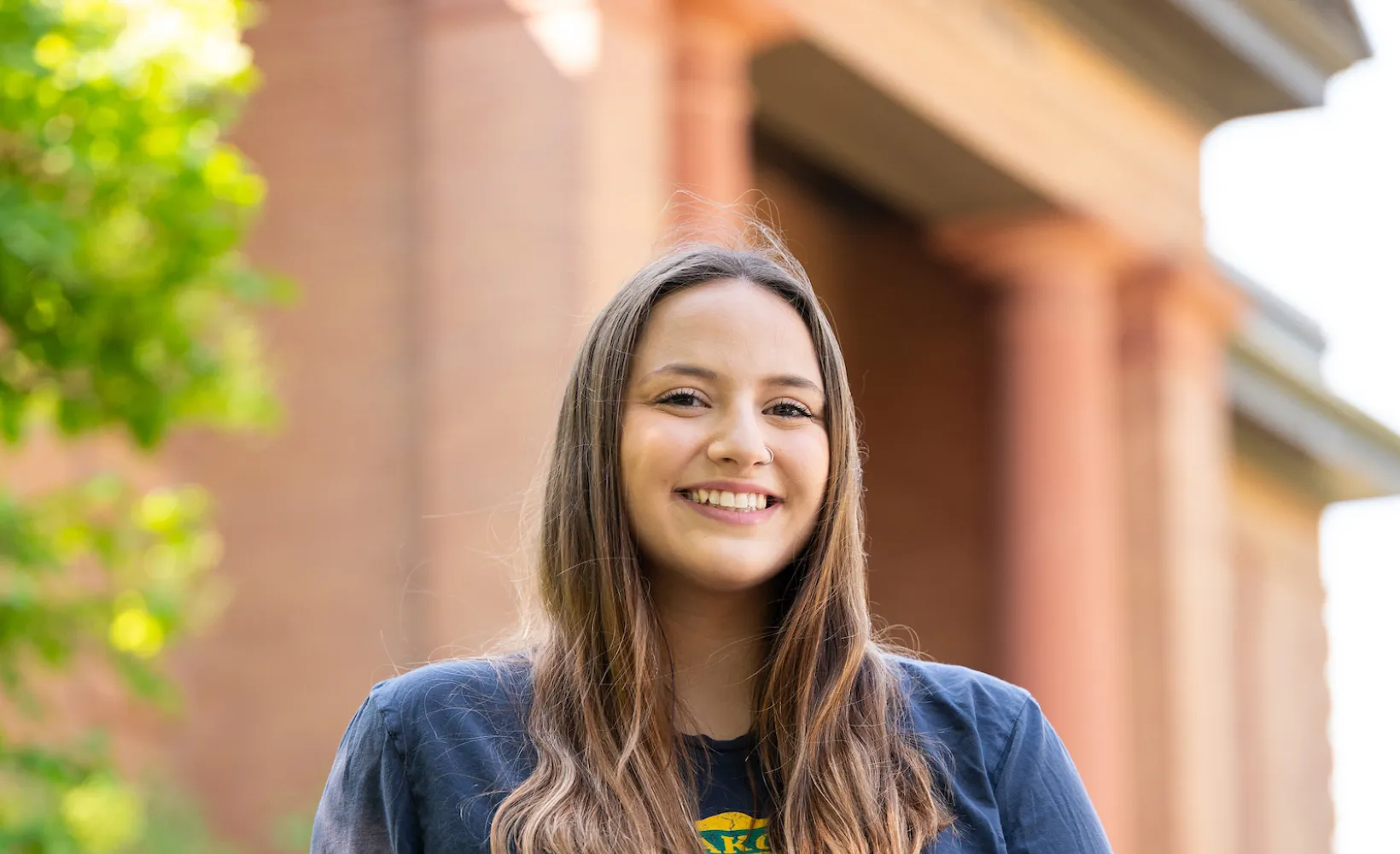 Student sitting in front of admission building
