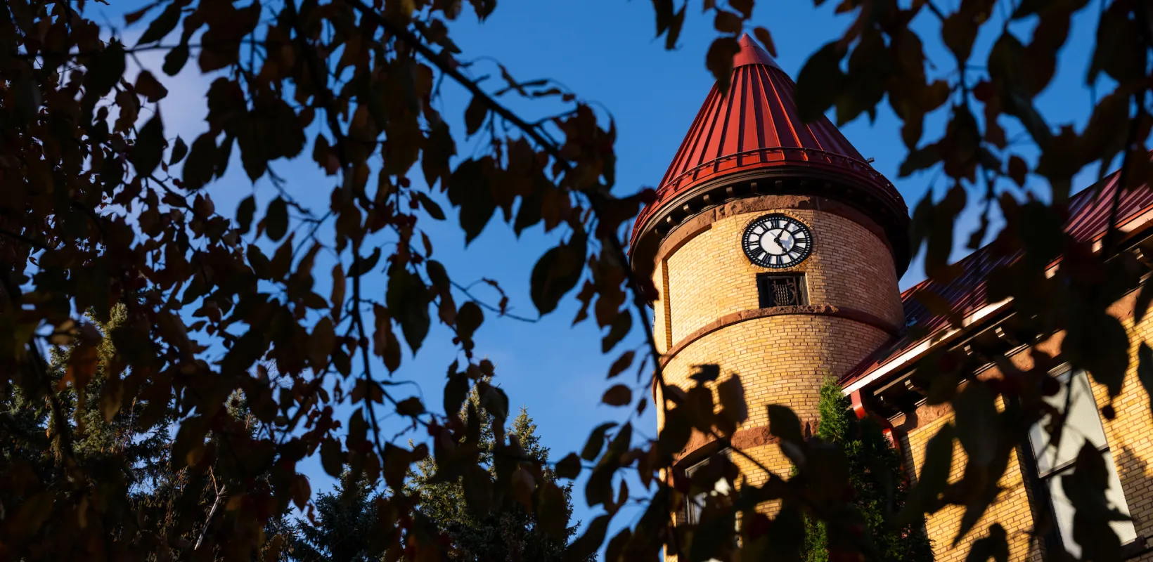 angled photo of the clock of Old Main against a deep blue sky