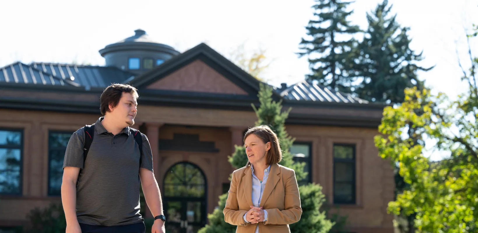 student and professor walking on campus