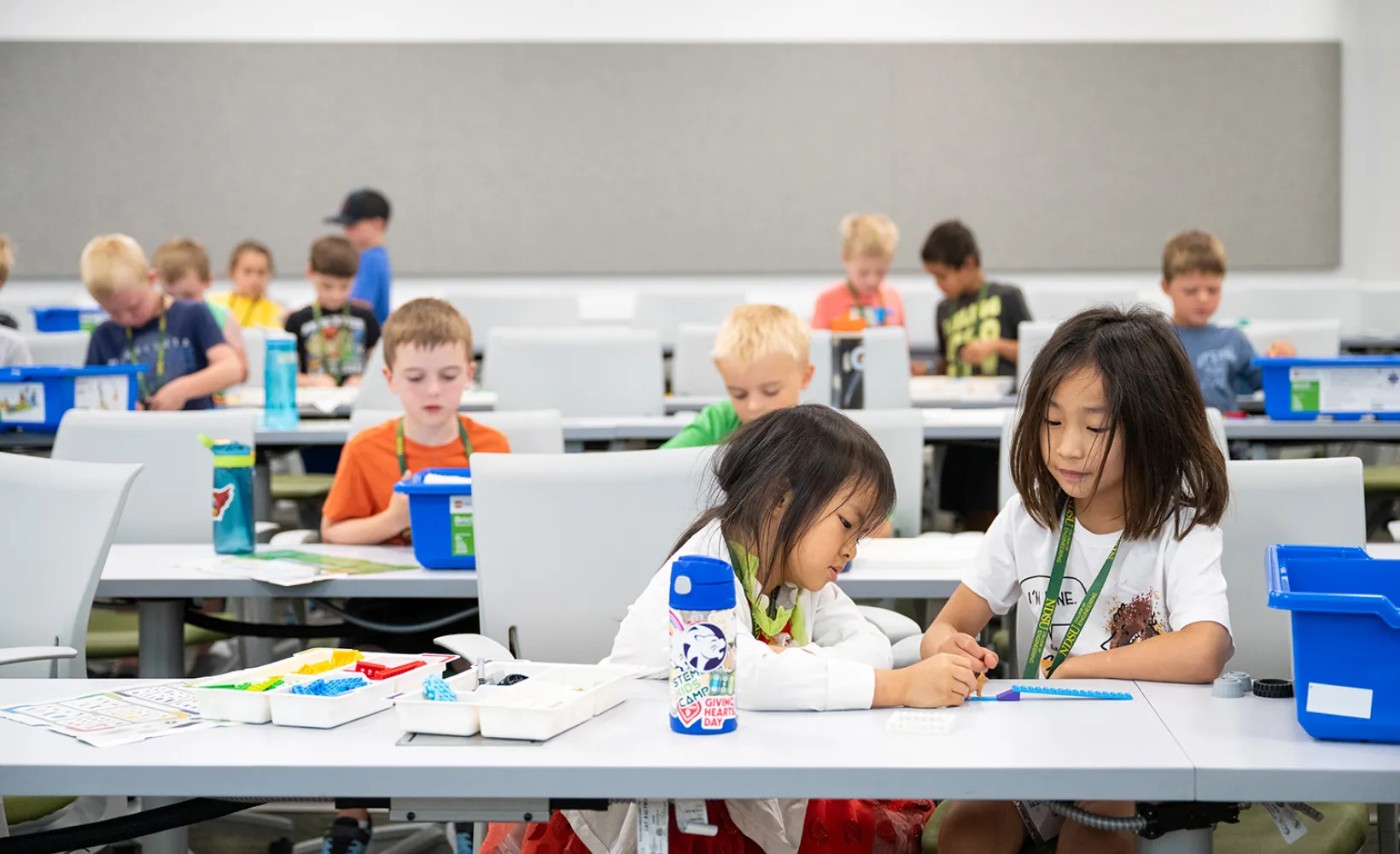 Various kids working at a table on a stem activity