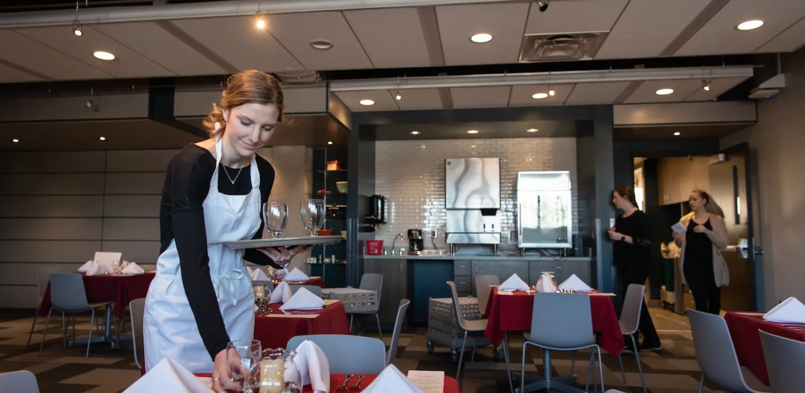 an NDSU student sets a table at 800 Café