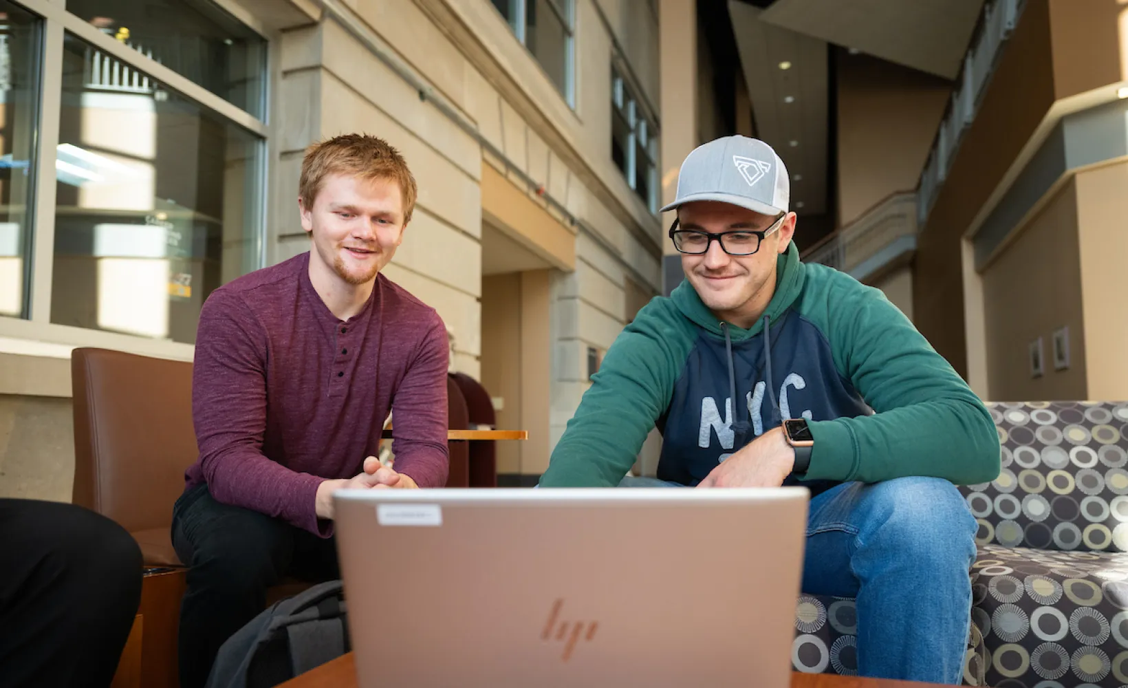 Business students review their coursework on a laptop