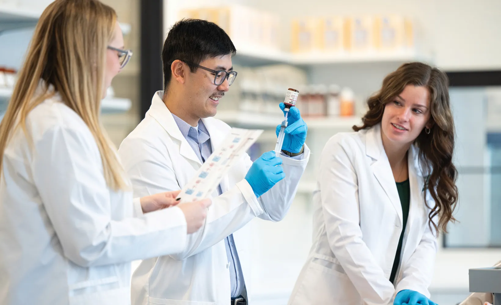 Pharmacy students practicing in a lab.