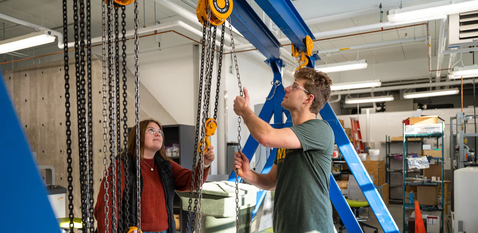 students working in a shop with a hoist