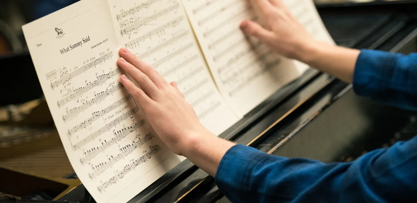 student looking at sheet music on a piano