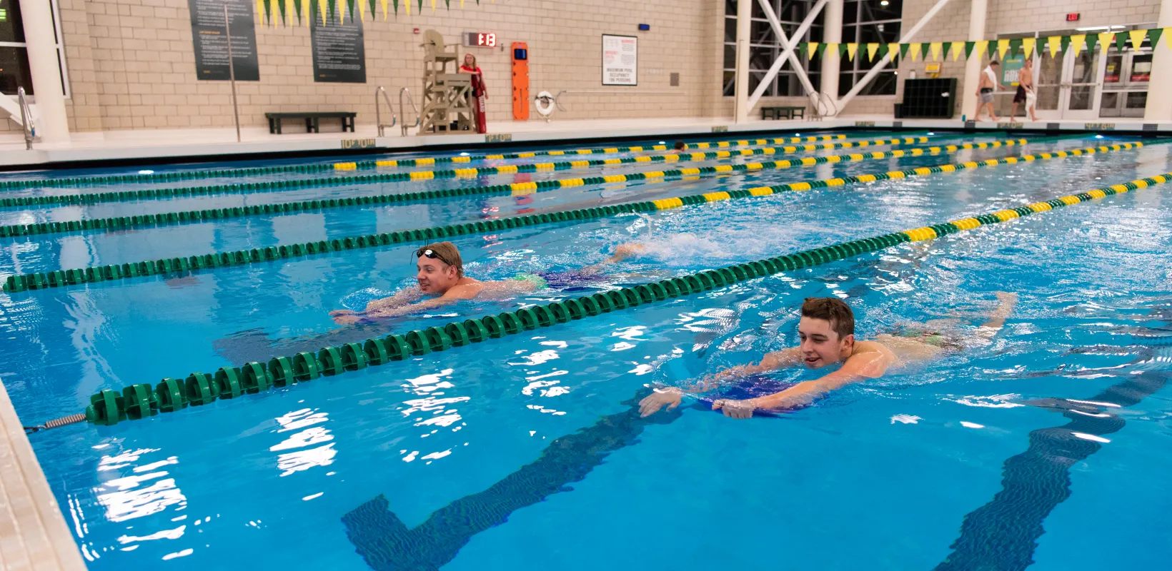 Students swimming in lap pool at Wellness Center