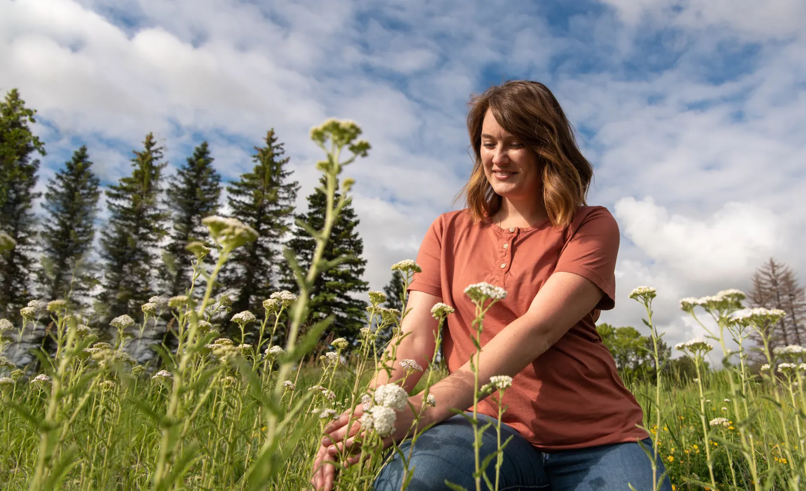 graduate student in a field studying wild flowers
