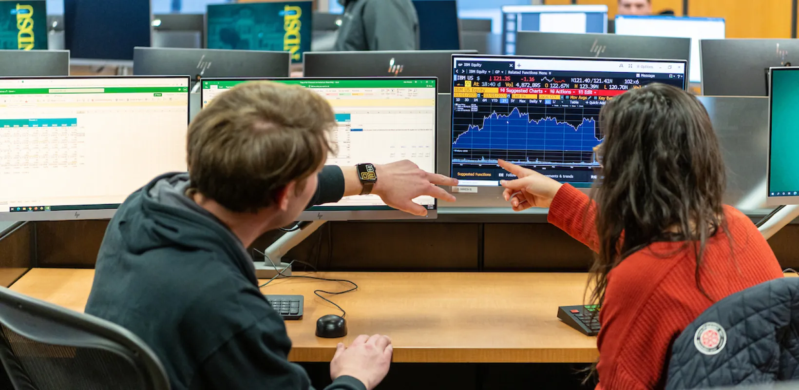 Two students looking at business reports and charts