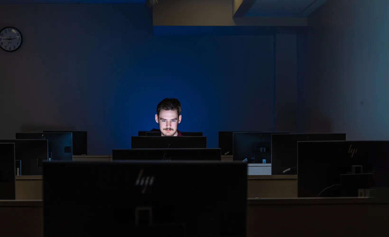 student working alone in a dark computer lab