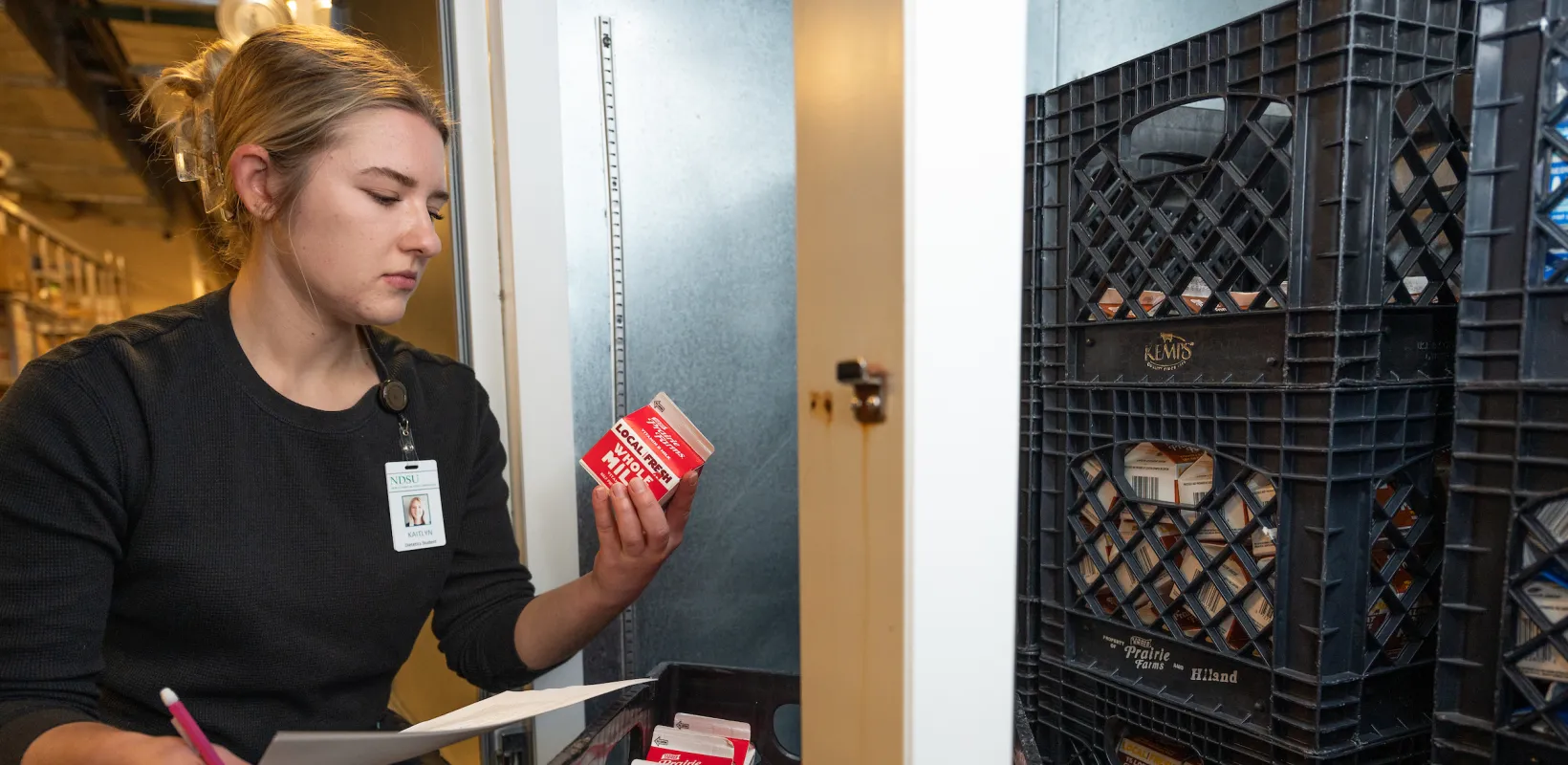 student taking inventory of dairy products in a cooler