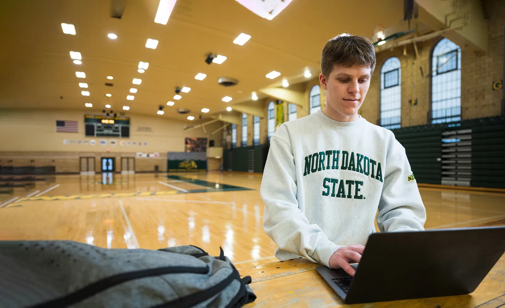 Sport Management student working on a laptop in the Bentson Bunker Fieldhouse