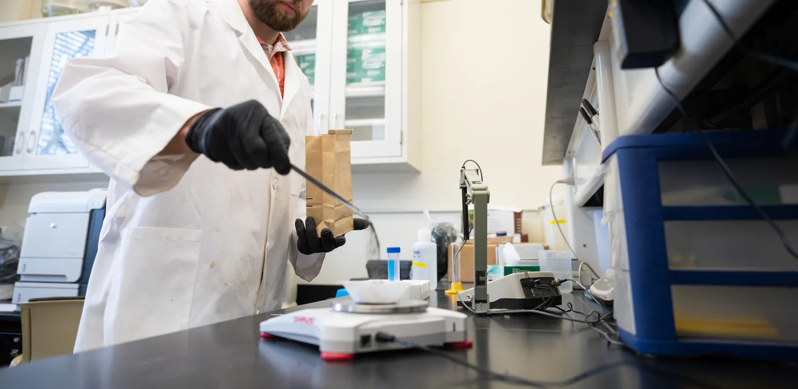 student weighing samples of dirt on a scale