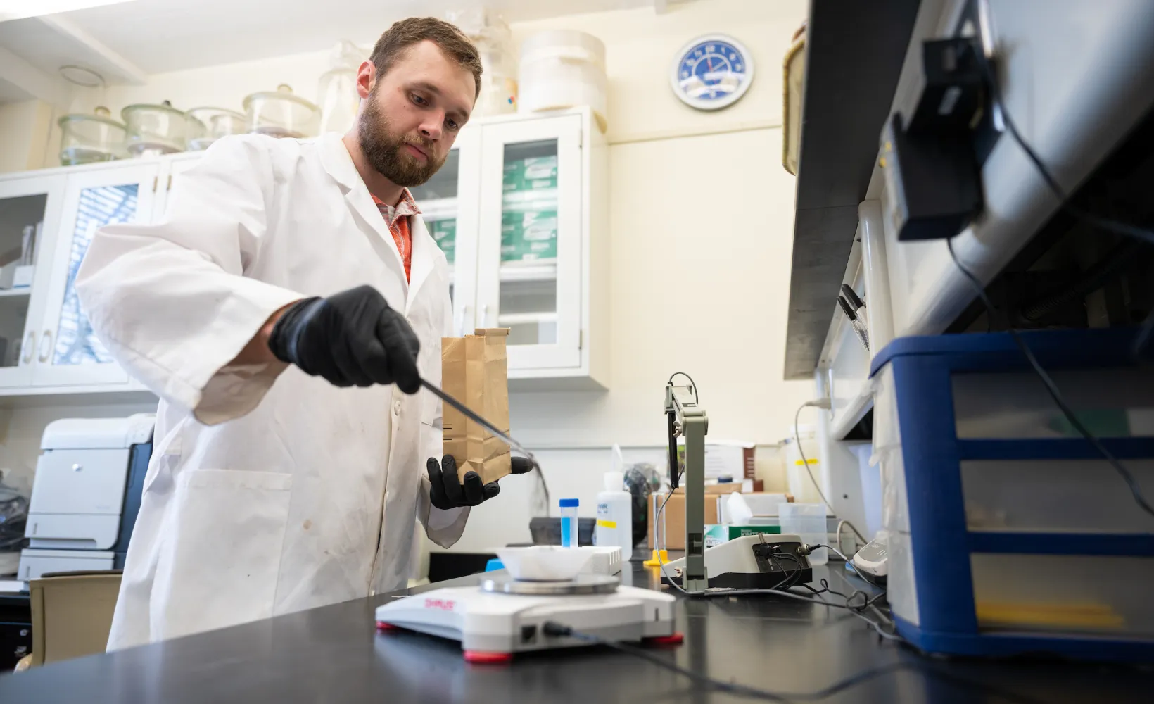 student weighing samples of dirt on a scale