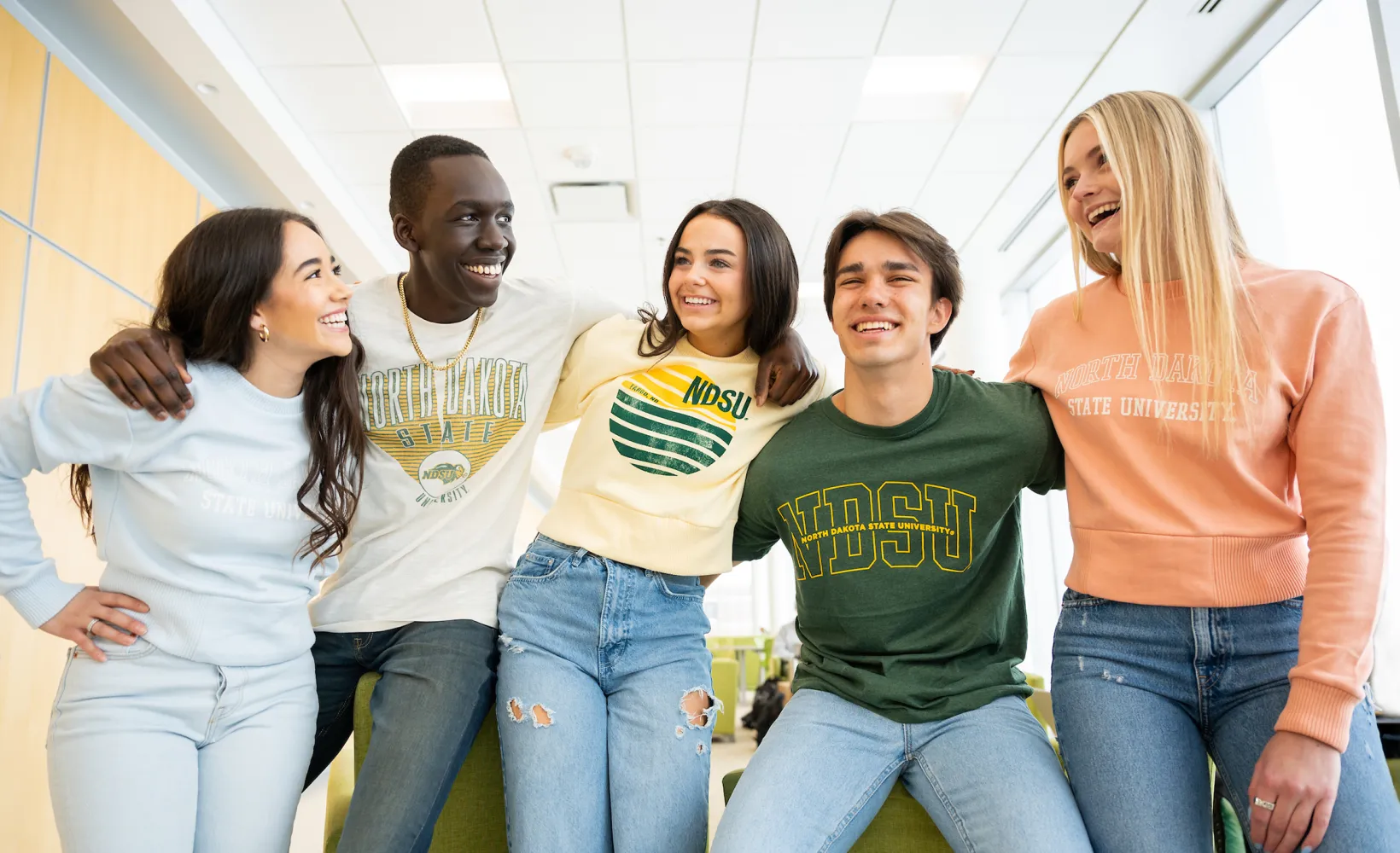 five students talking and laughing while wearing NDSU sweatshirts