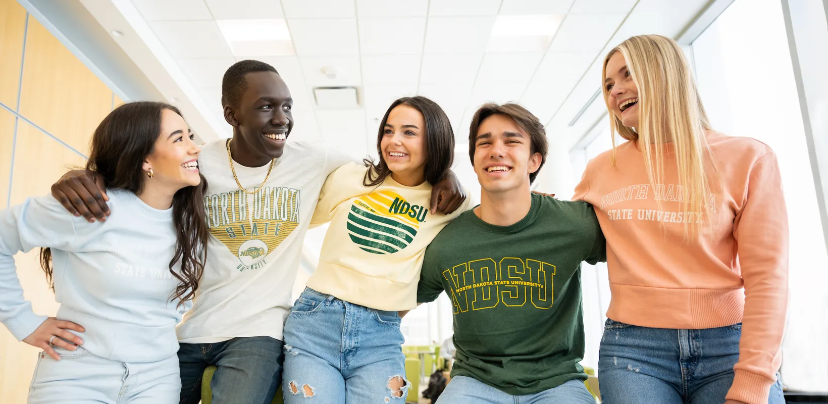 five students talking and laughing while wearing NDSU sweatshirts