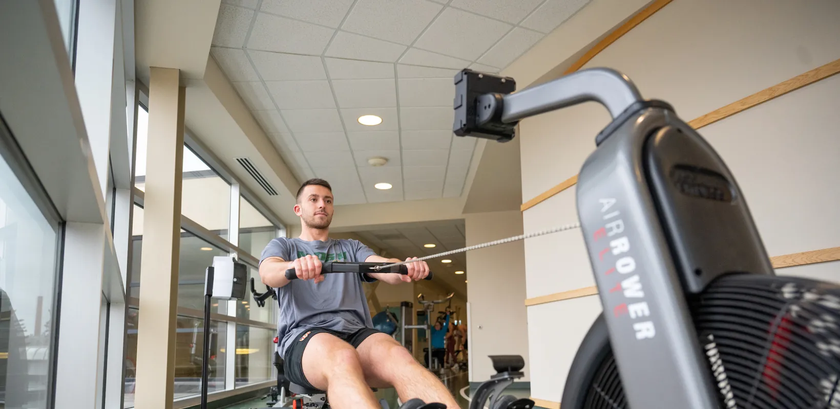 student exercising on a rowing machine