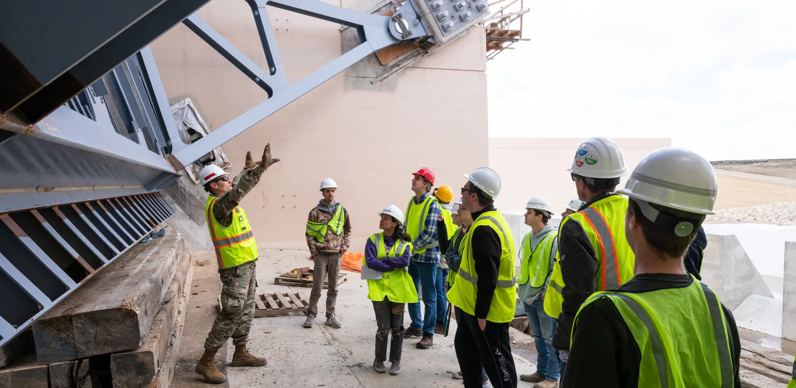 construction students touring a site and listening to an explanation by a construction worker