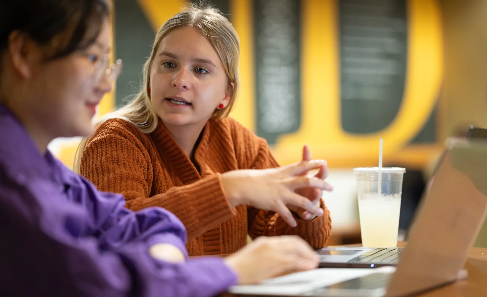 students talking about a project in a campus building