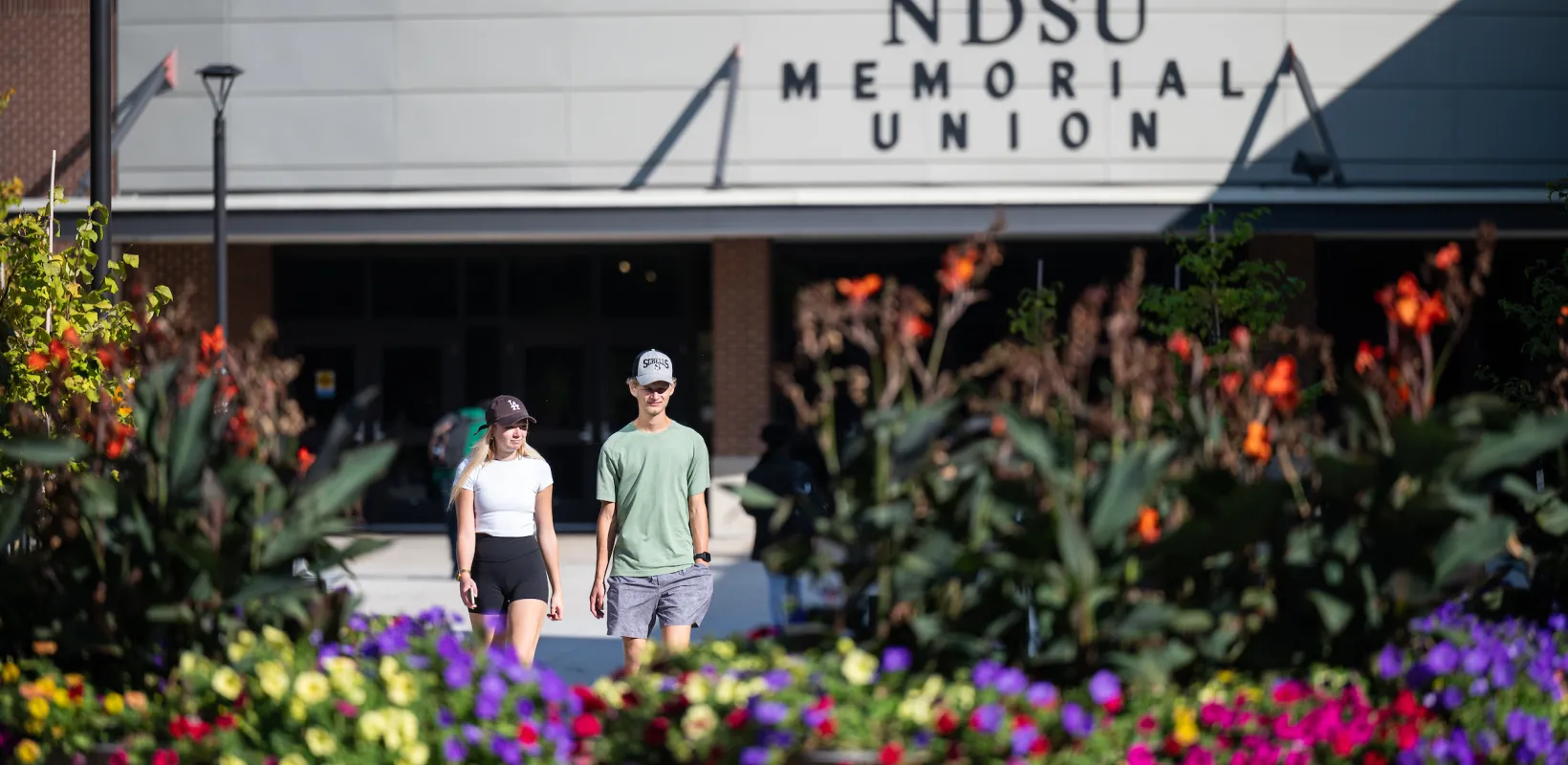 Students walking in front of the NDSU Memorial Union during the spring. 