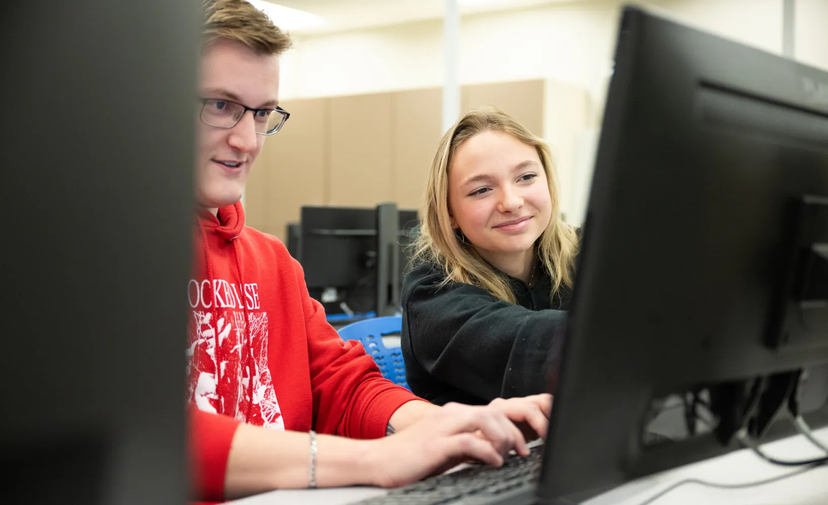 cybersecurity students working on a program in a lab