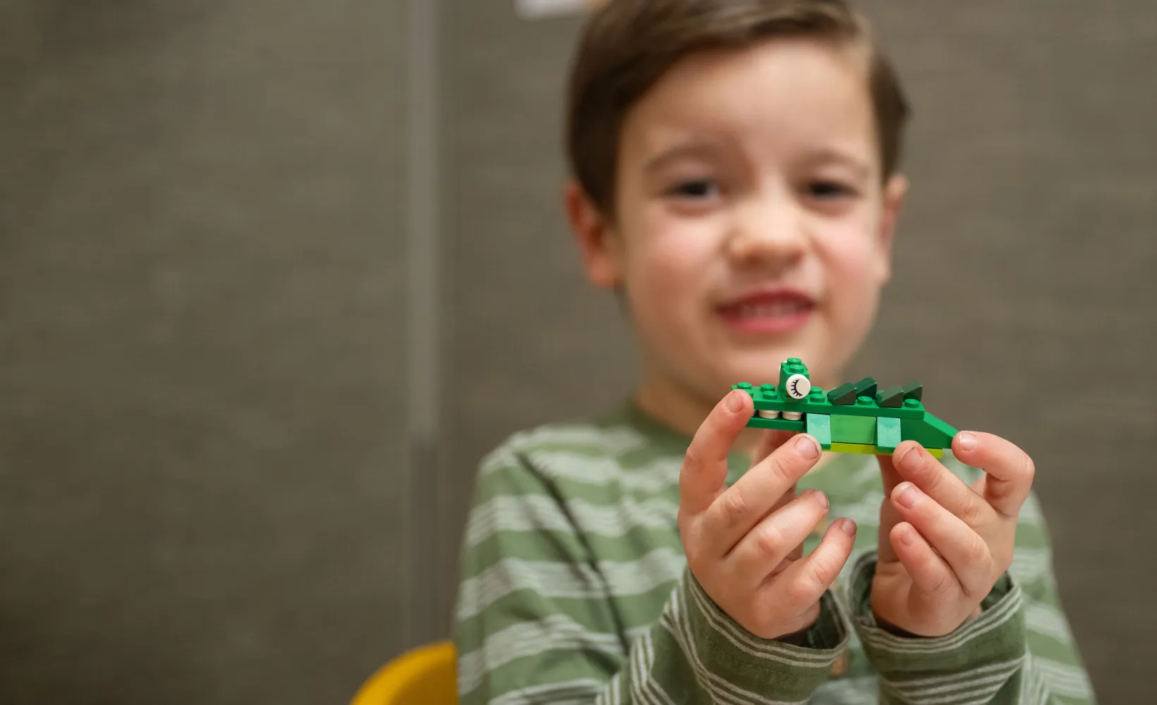 child holding up a Lego creation as part of Human Development and Family Science research