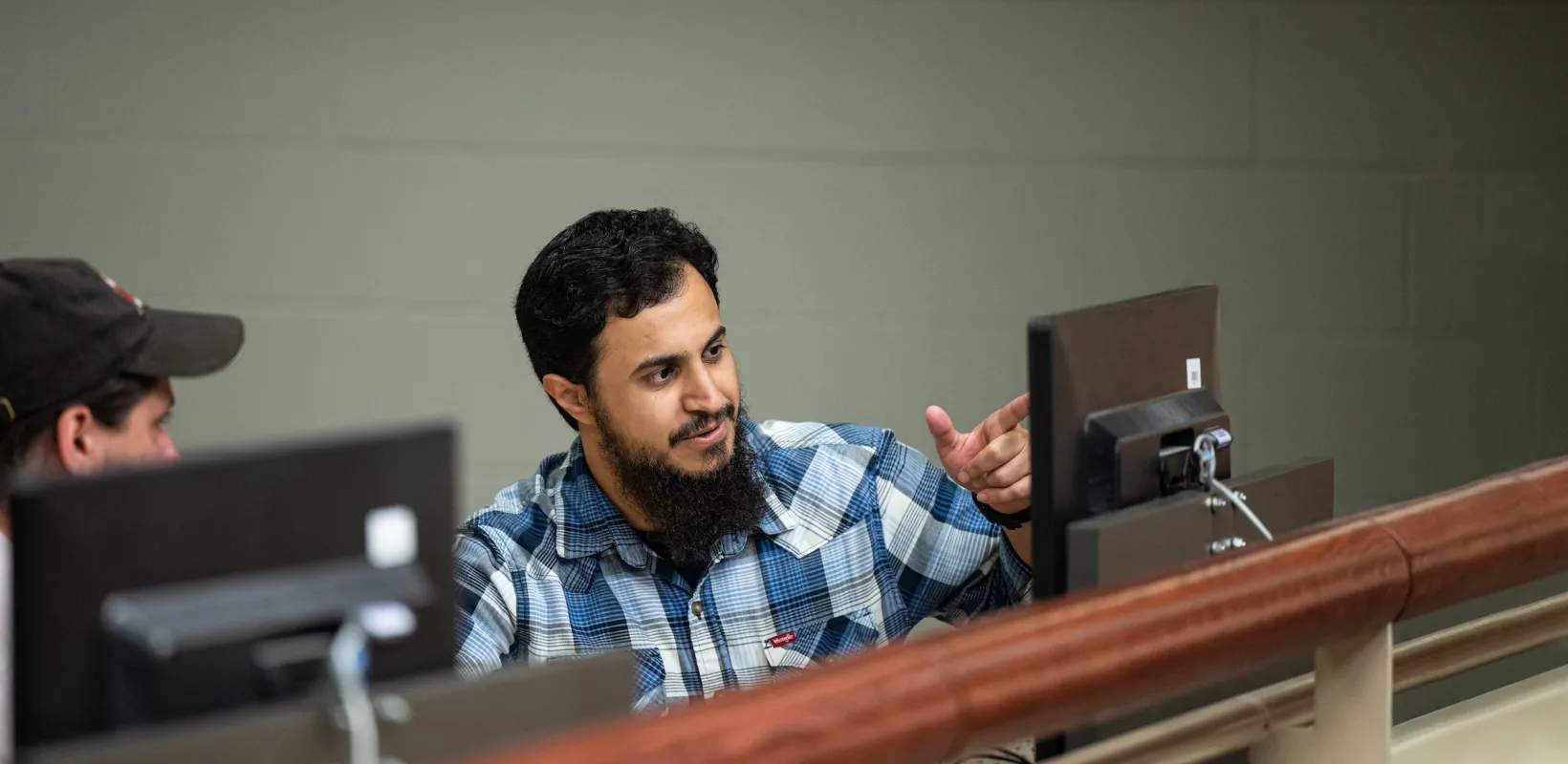 student discussing project on computer in a computer lab