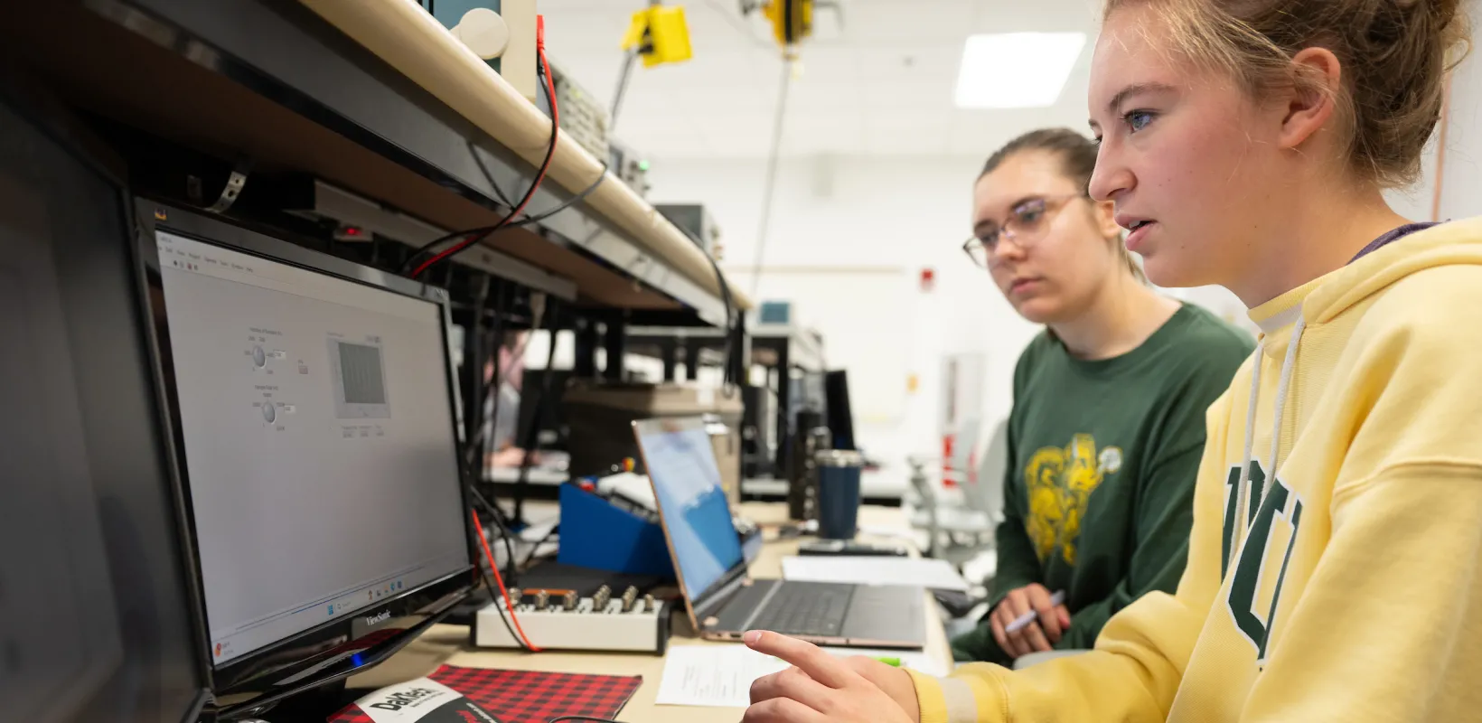 students testing computer hardware at a workbench