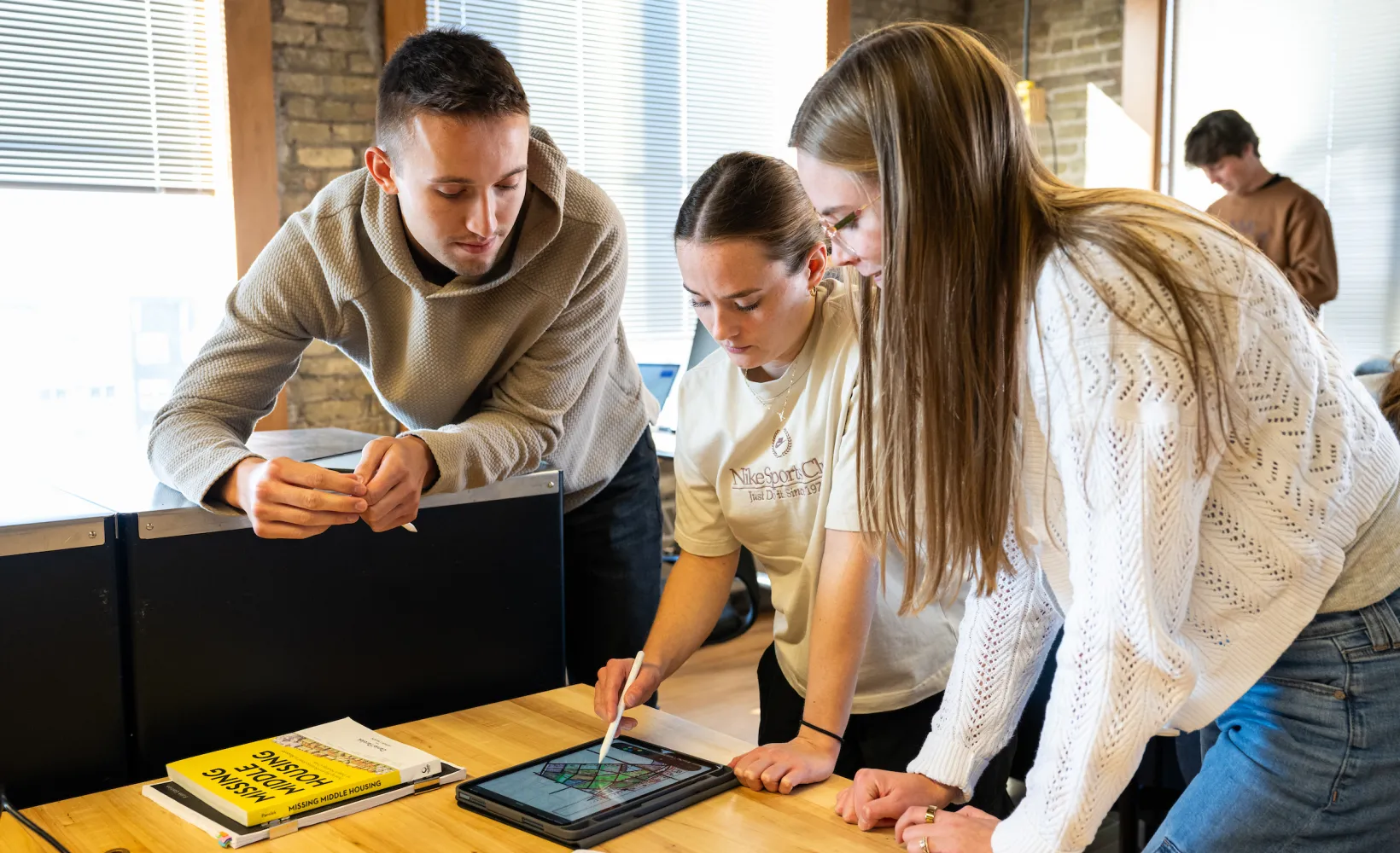 architecture students looking at a project on a tablet