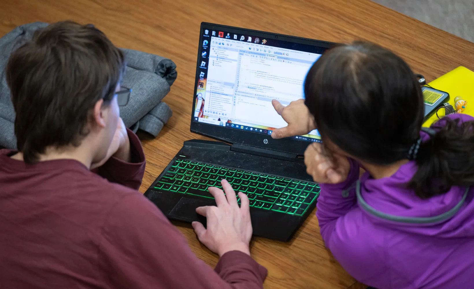 students reviewing code on a laptop screen
