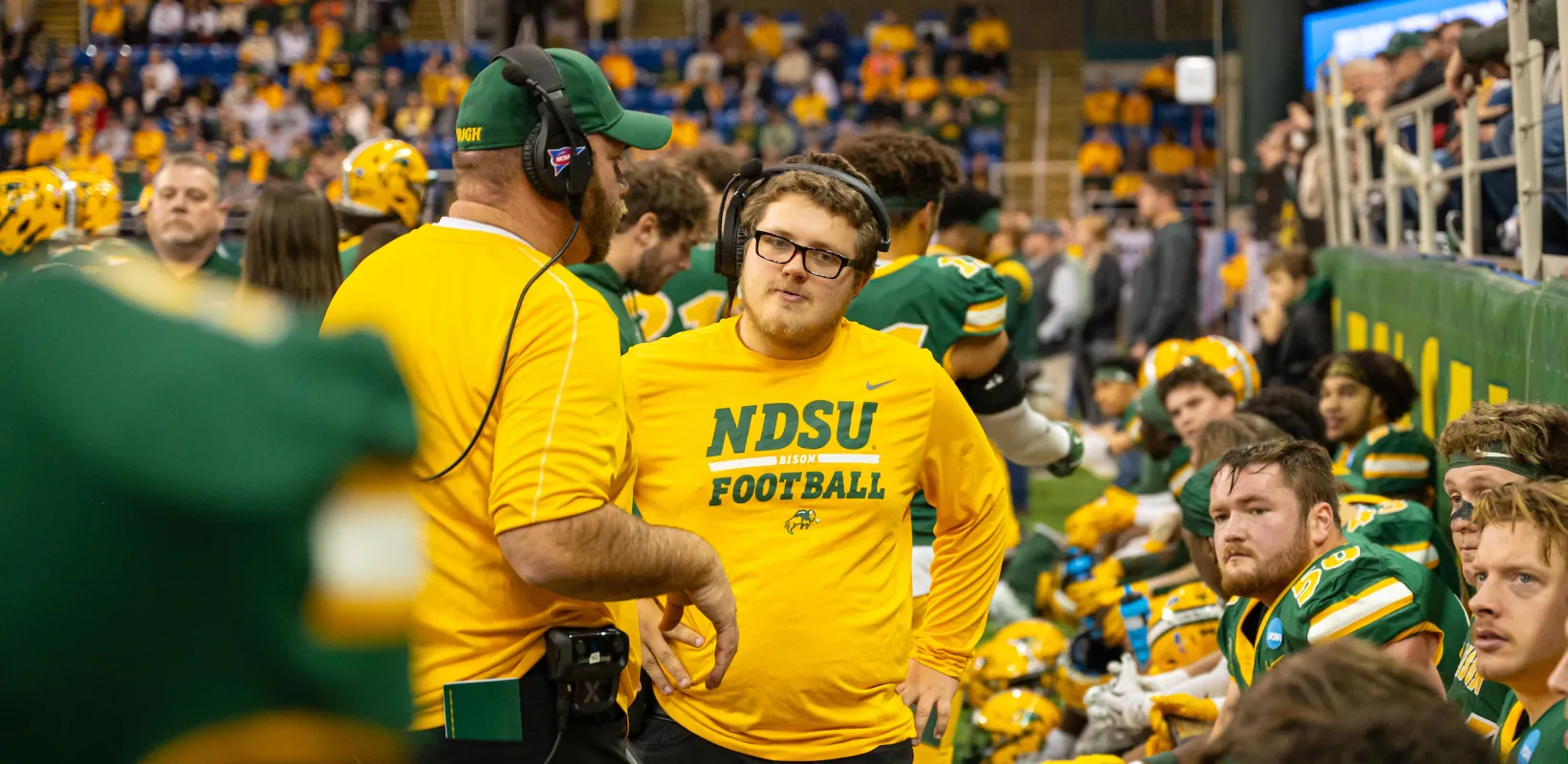 coaching staff and players on the sideline of a football game