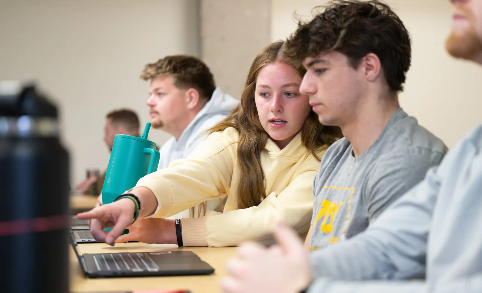 students looking at a laptop screen during class