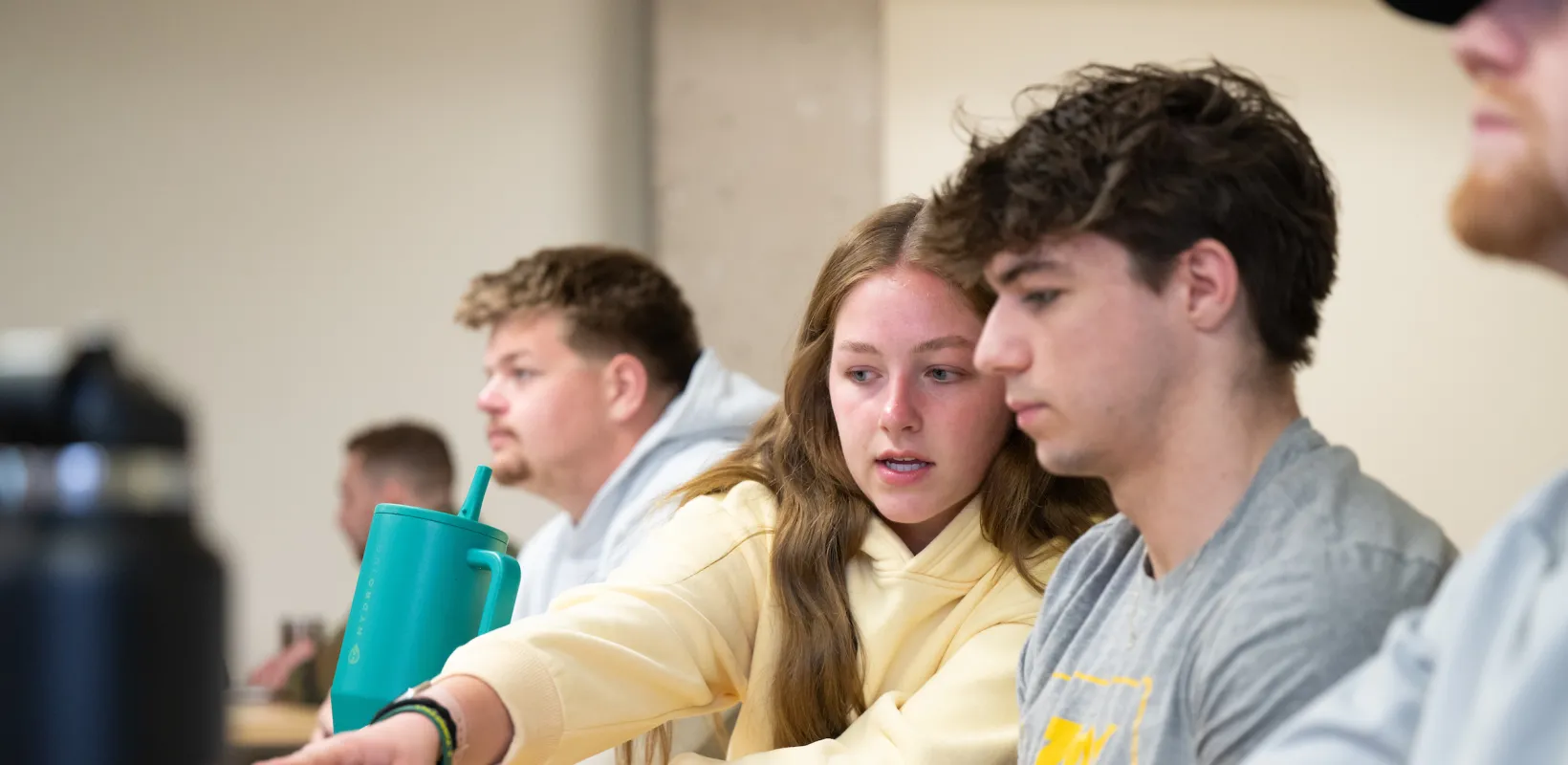 students looking at a laptop screen during class
