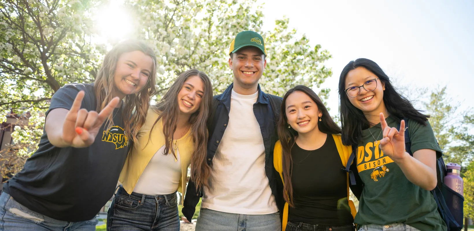 students standing in group, smiling at camera