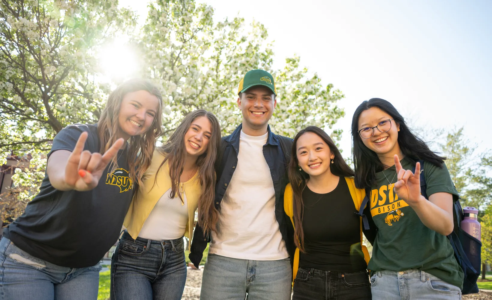 students standing in group, smiling at camera