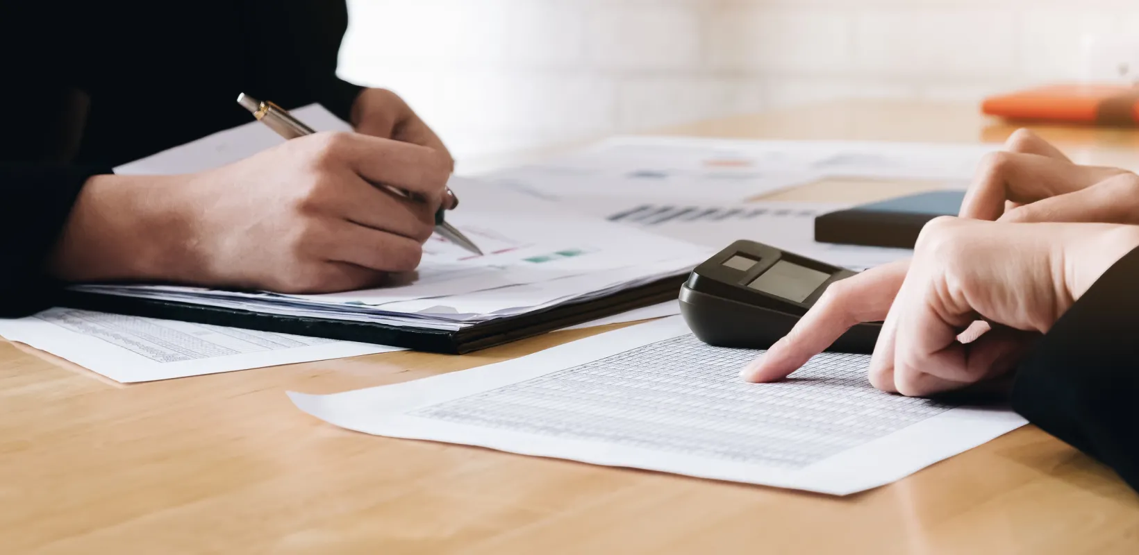 two people going over paperwork in an office