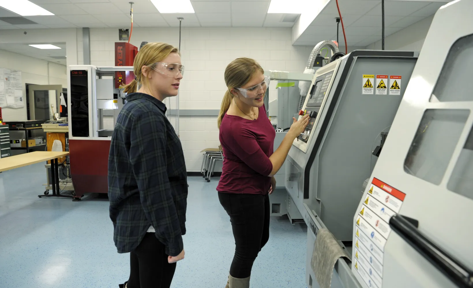 two female students work in lab on testing equipment